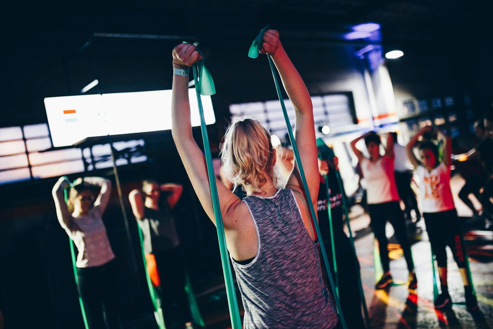 Small fitness group exercising together with resistance bands in a gym class