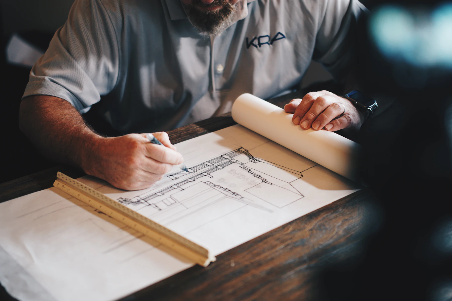 Architect marking a detailed building plan during pre-construction planning